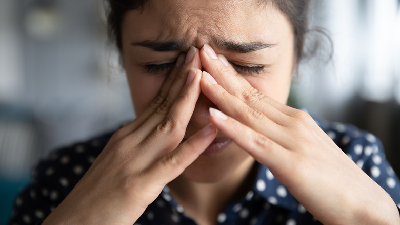 a woman holding her hands to her face in distress