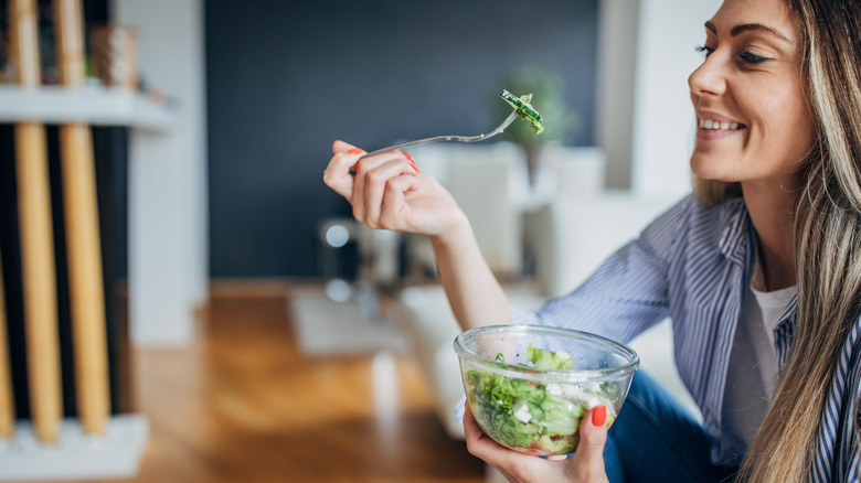 Woman eating broccoli 