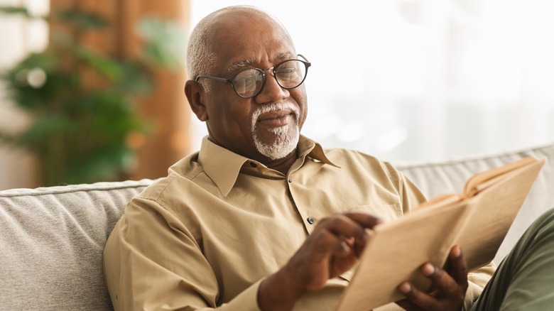 older Black man sitting reading a book