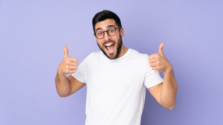 man giving thumbs up purple background