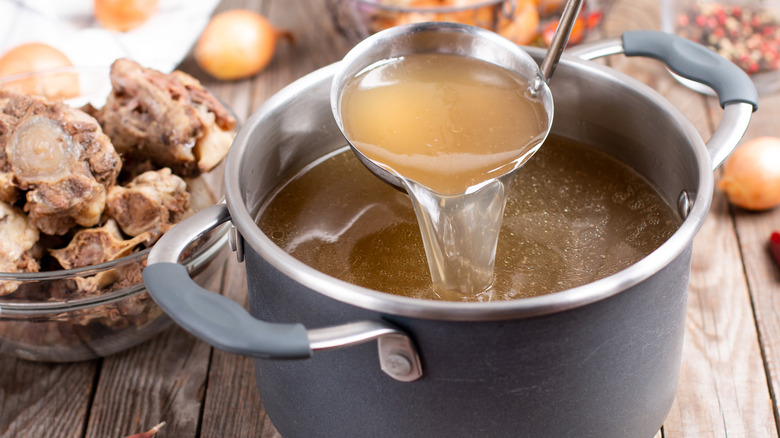 bone broth being poured from ladle