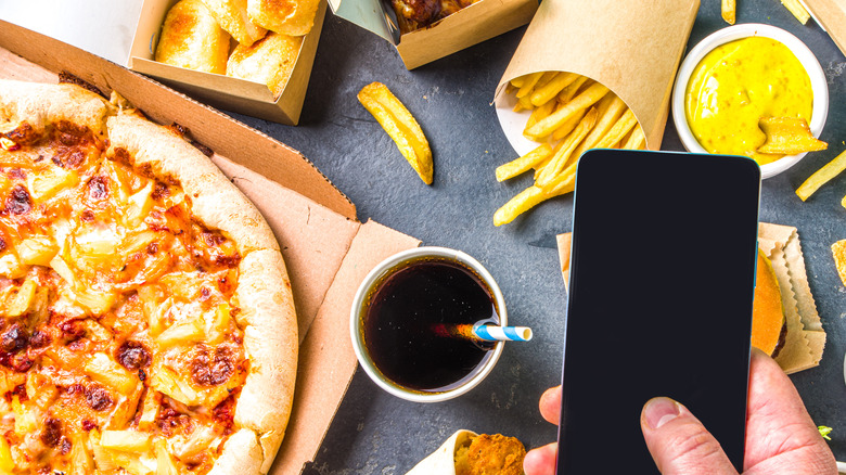 man taking photo of junk food