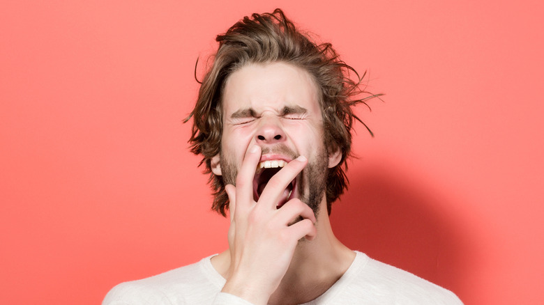 man yawning with messy hair