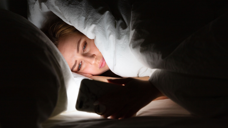 woman on smart phone in bed