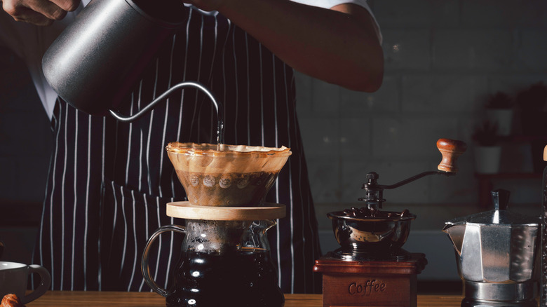 barista pouring coffee into beaker