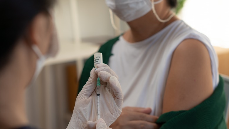 Doctor filling syringe from vaccine vial