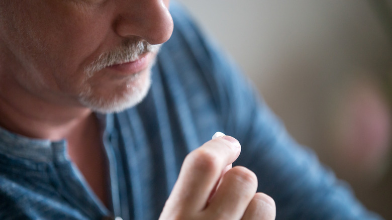 Elderly man with a dubious pill 