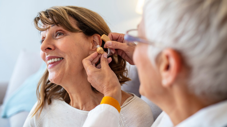 elderly woman being fitted for a hearing aid