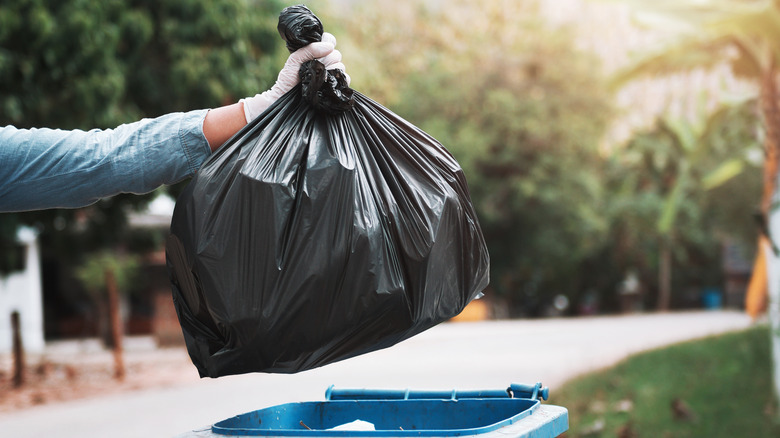 trash bag being thrown away