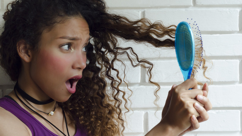 woman pulling brush out of her hair