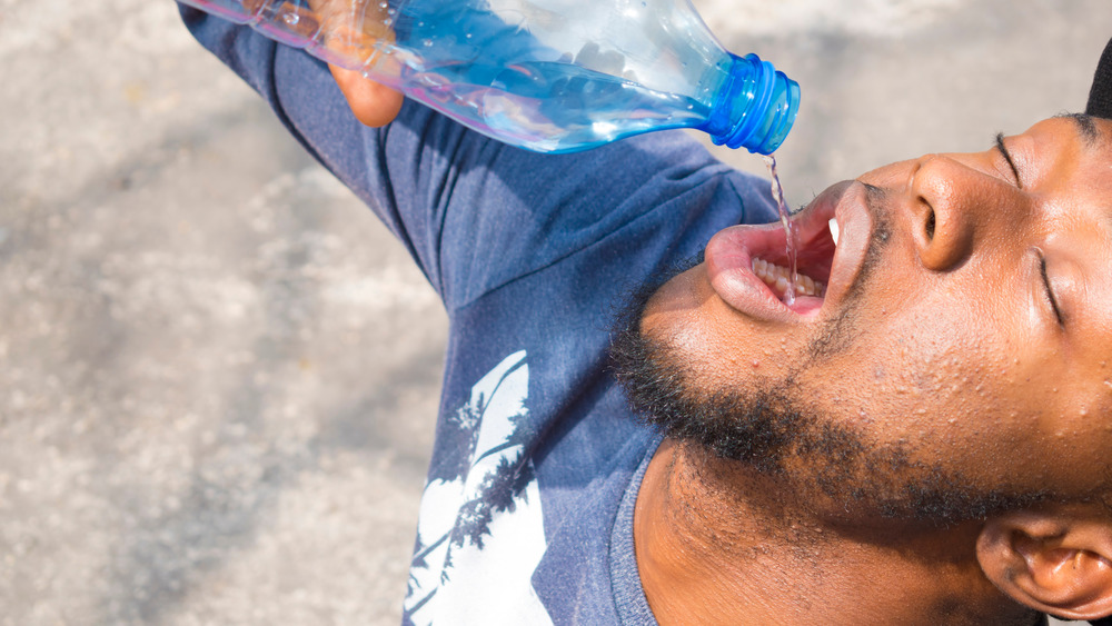 man pouring water into mouth