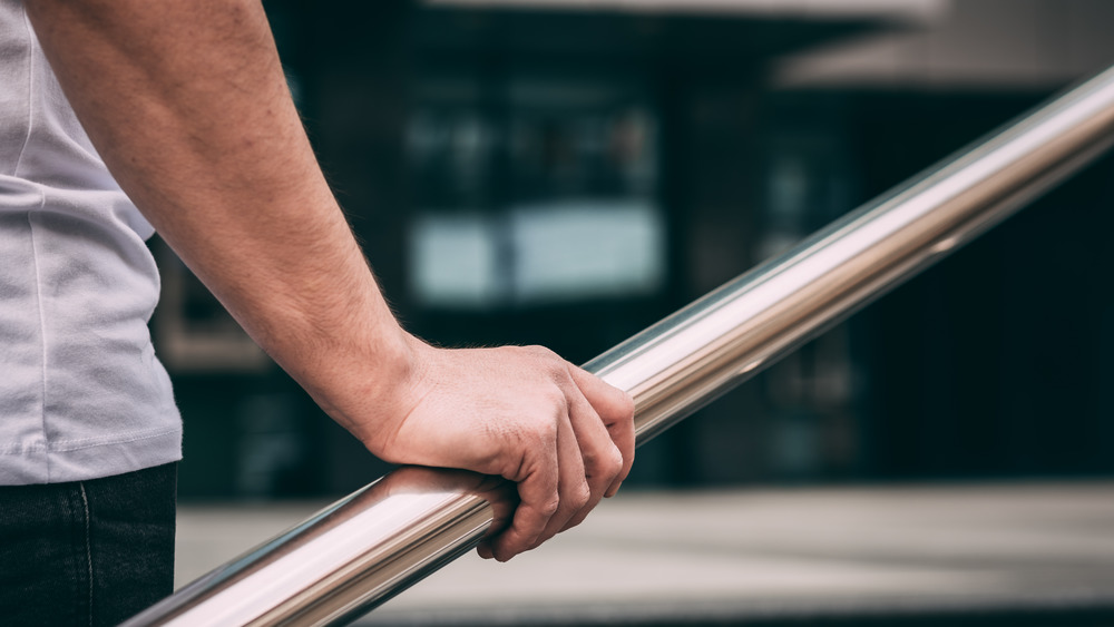 man gripping railing