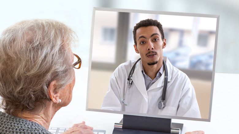 Older woman consults with her doctor via telemedicine