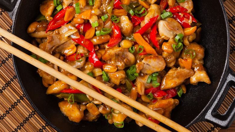 wok with chicken, peppers, and peanuts