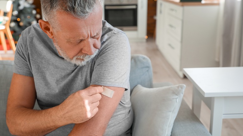 Man applying skin patch at home