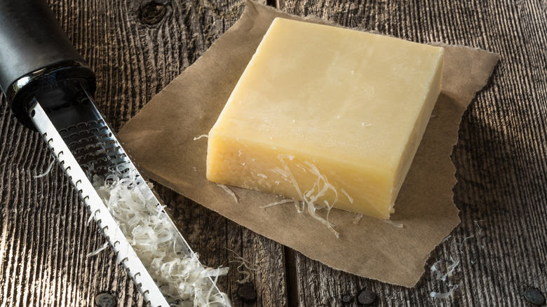 block of Gruyere cheese on a cutting board