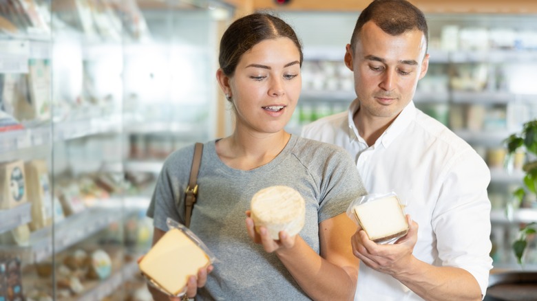 couple picking out cheese at a market