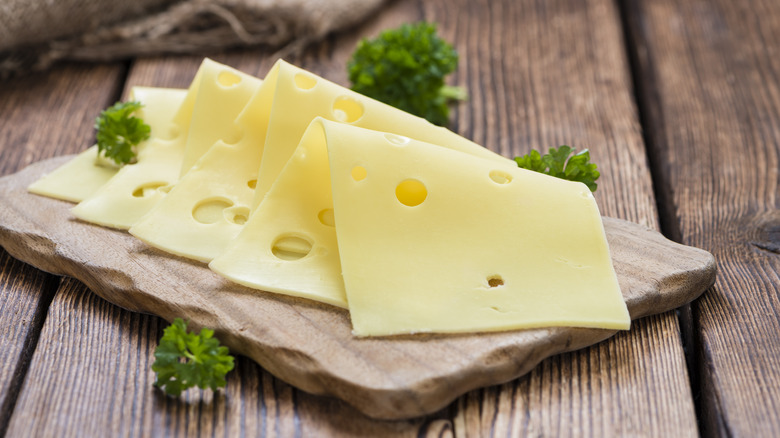 slices of Swiss cheese on a cutting board