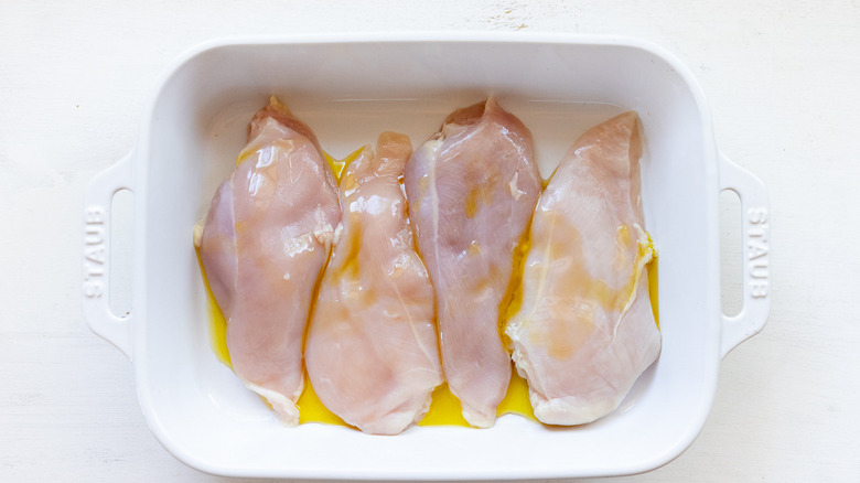 oiled raw chicken in pan