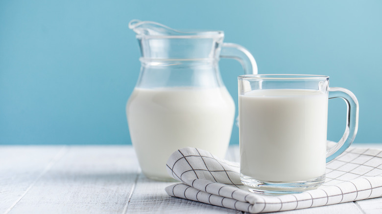 a glass and a jug of milk