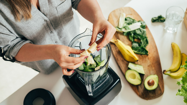 woman making green smoothie