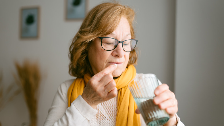 Woman taking medication with water