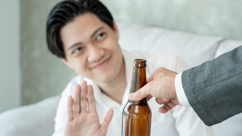 Man declining an offered beer