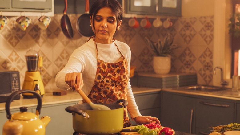 Young woman in apron cooking a meal