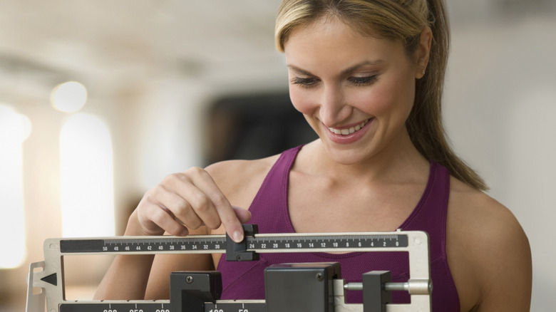 Woman smiling while weighing herself