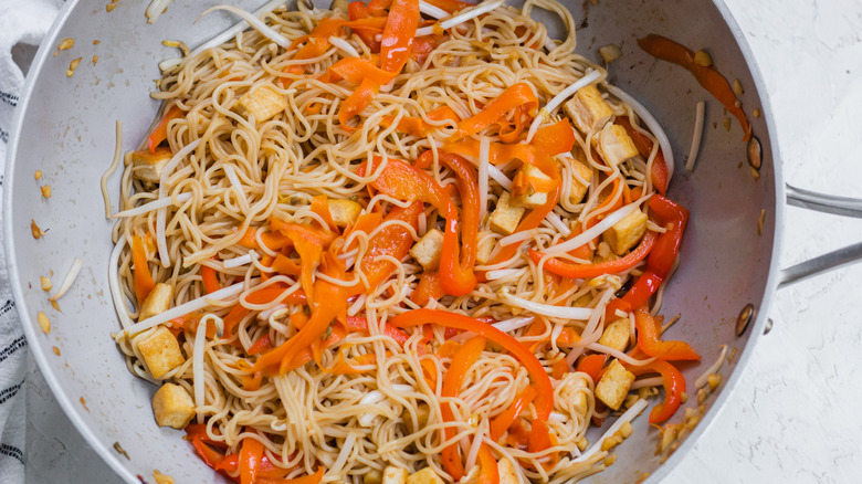 Noodles, vegetables, tofu in skillet