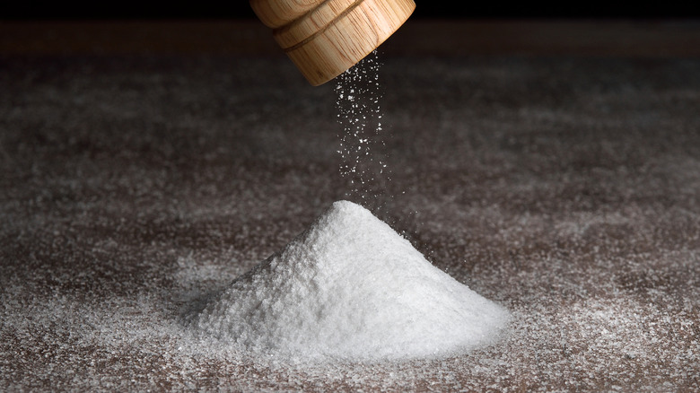 salt falling from a wooden grinder