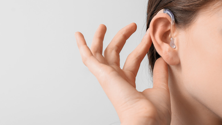 woman adjusting hearing aid