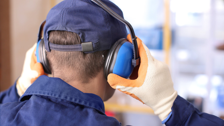 man covers ears with ear protector