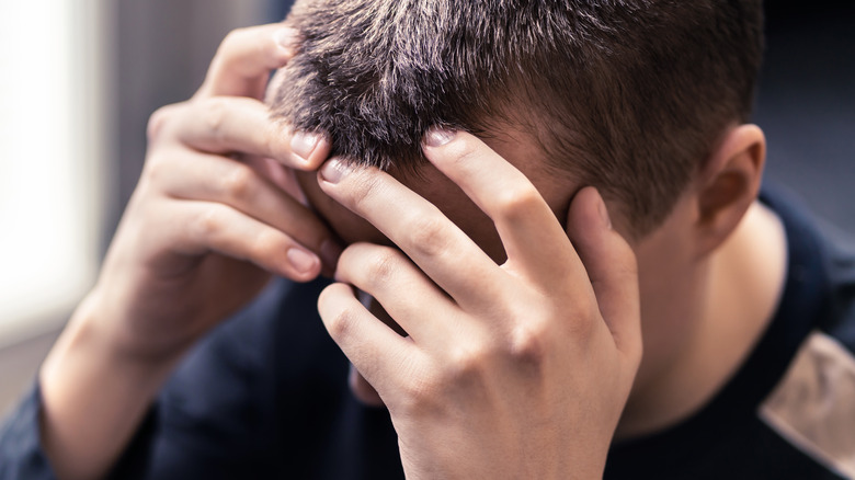 man holding his head under stress