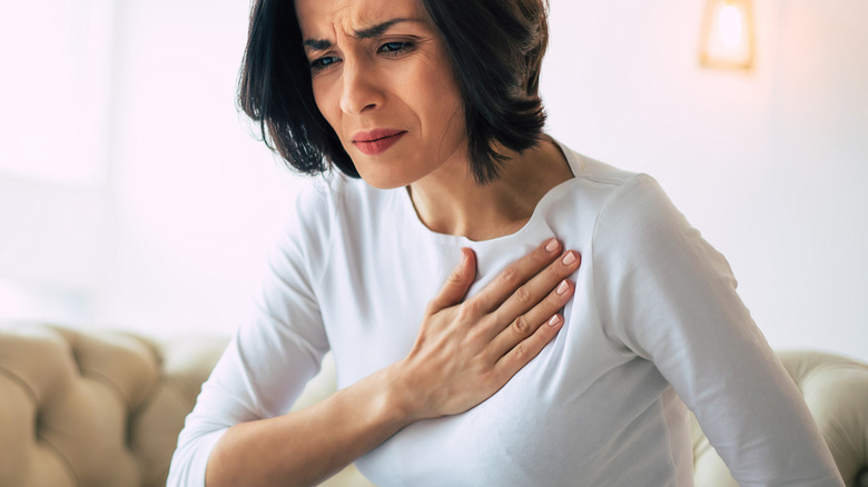 woman gripping her chest in pain