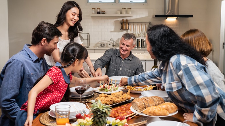 large family enjoying dinner at home