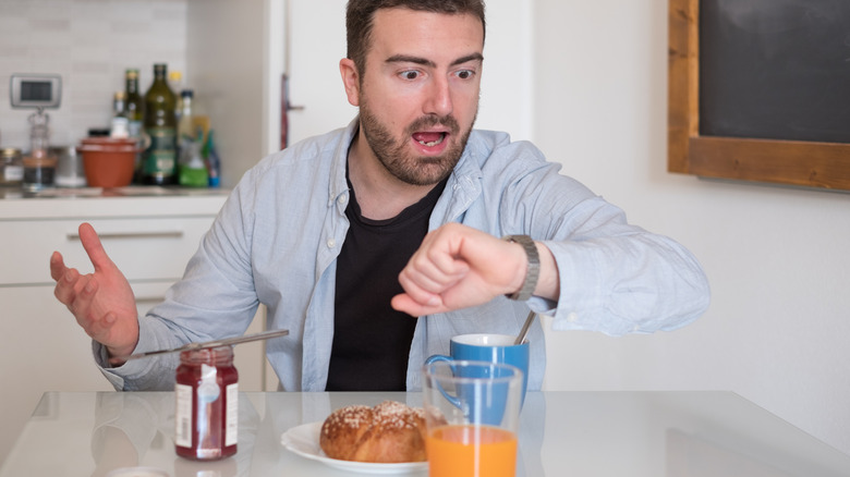 panicked man looking at watch