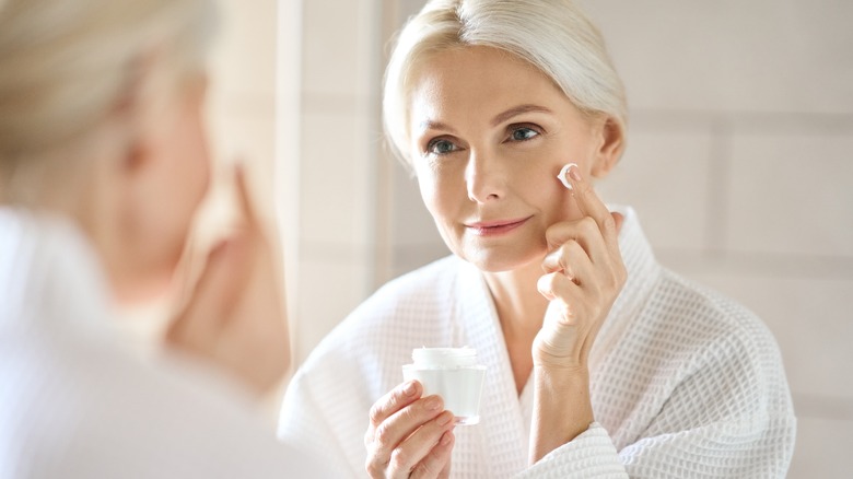 Older woman applying face cream