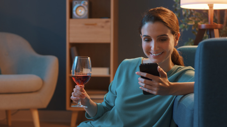 A woman drinks wine at home
