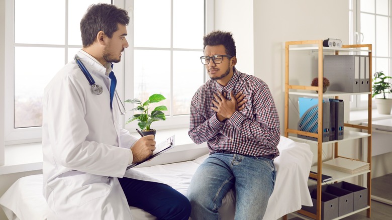 Doctor speaking to man with chest pain 