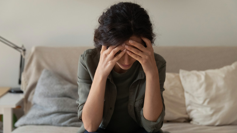 Distressed woman with head in hands