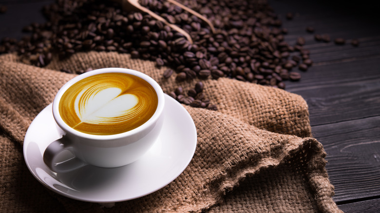 Latte surrounded by coffee beans