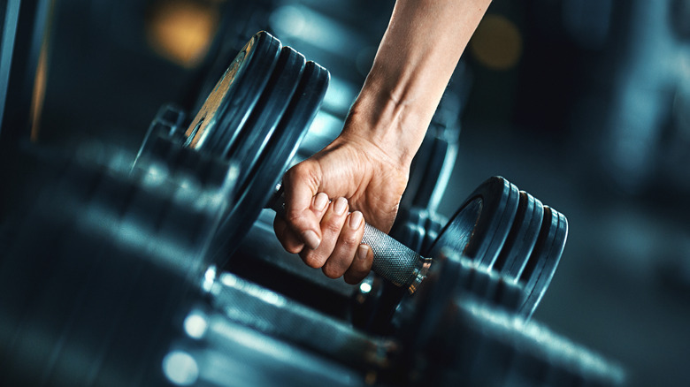 hand reaching for a heavy dumbbell