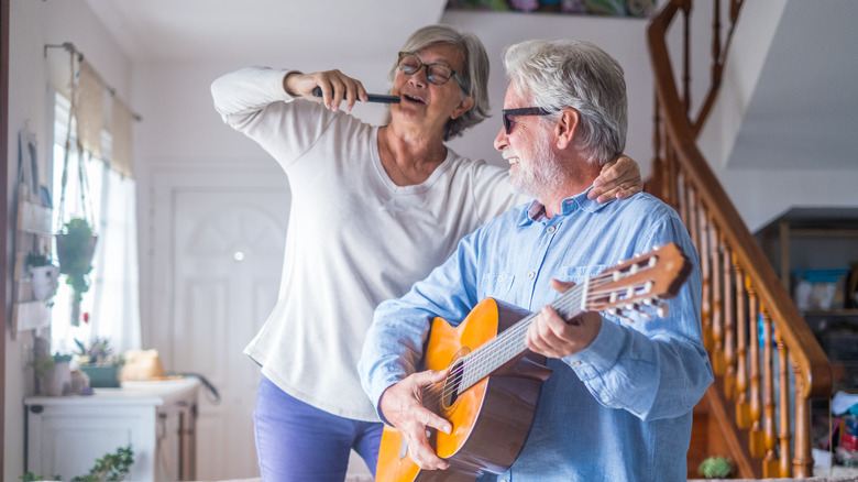 older couple singing and playing music at home
