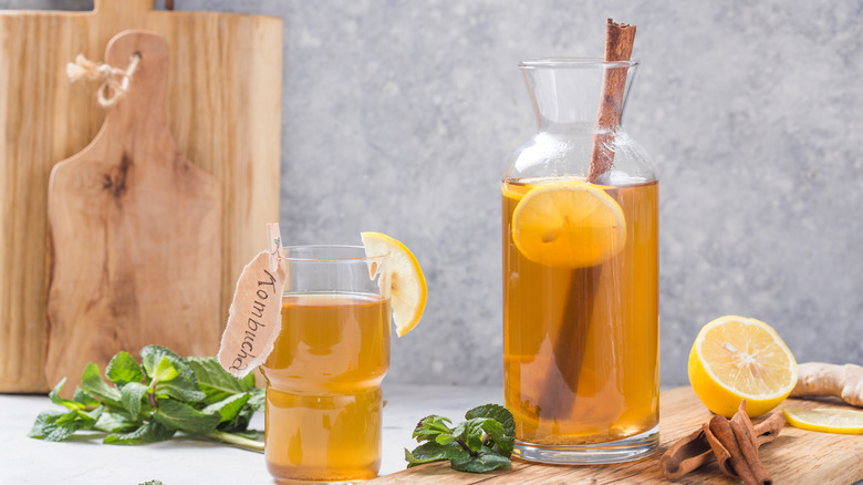 a pitcher and glass of kombucha