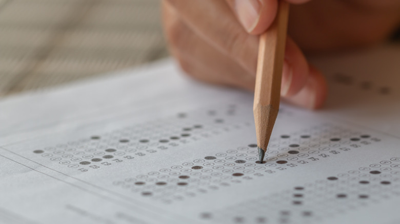 Person filling in multiple choice exam bubbles