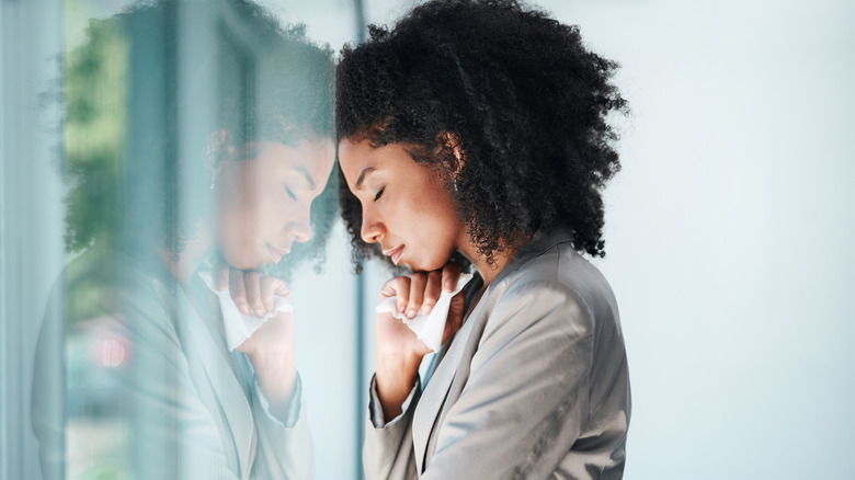 Sad woman leaning against window