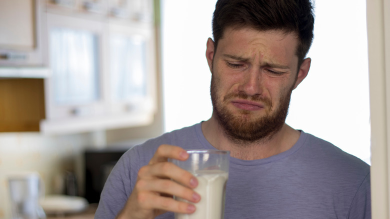 Man looking at spoiled milk 