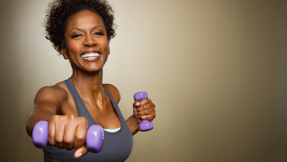 Smiling woman lifts hand weights