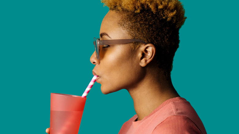 Woman sipping water through straw